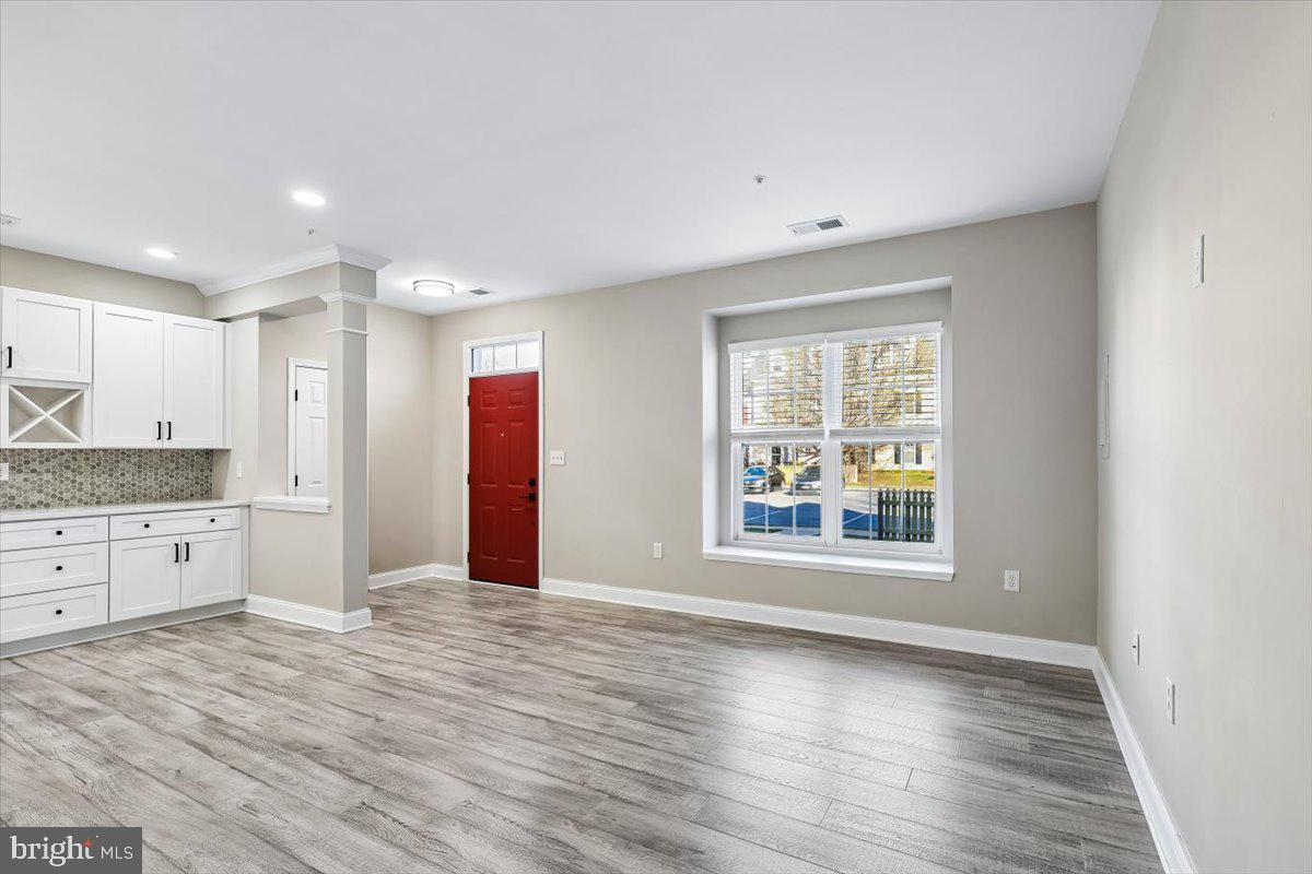 8737 Autumn Ridge Court Odenton, MD 21113 - Photo 13 of 46 a view of an empty room with window and wooden floor