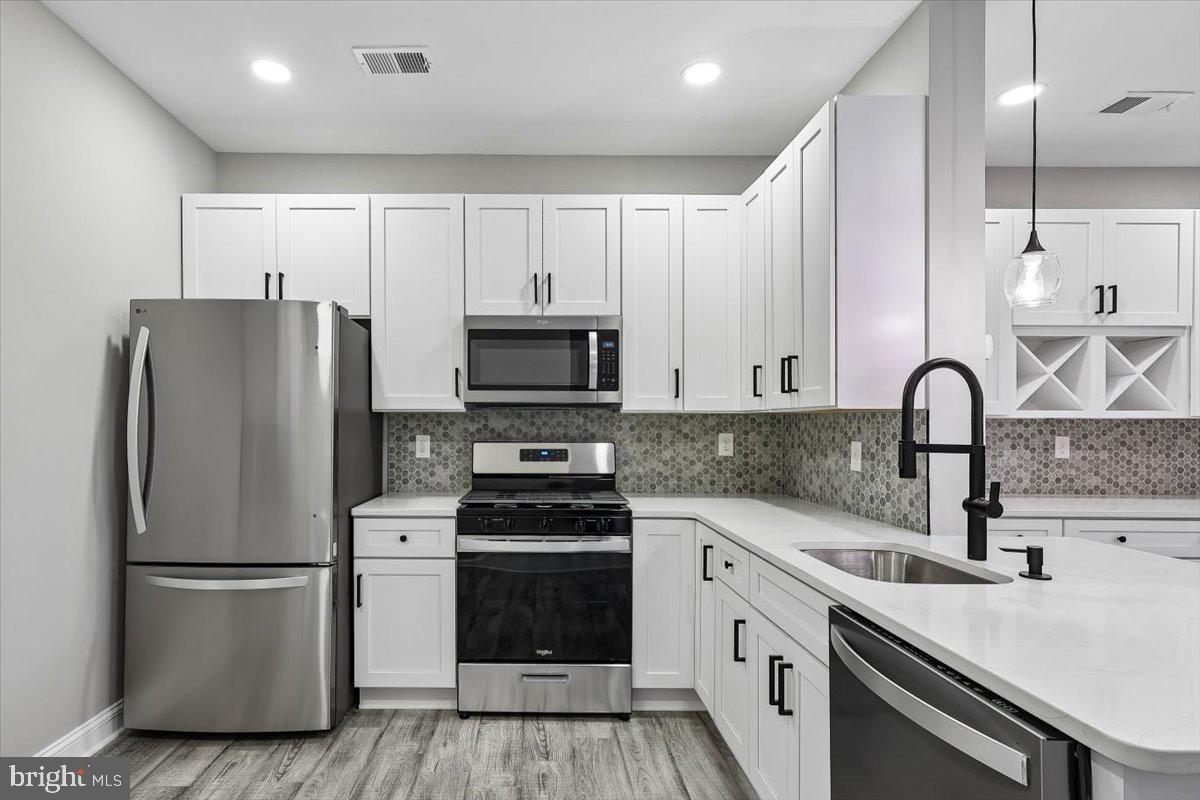 8737 Autumn Ridge Court Odenton, MD 21113 - Photo 2 of 46 a kitchen with a refrigerator sink and white cabinets
