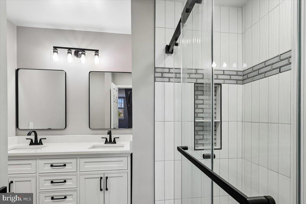 8737 Autumn Ridge Court Odenton, MD 21113 - Photo 23 of 46 a bathroom with double vanity and a mirror