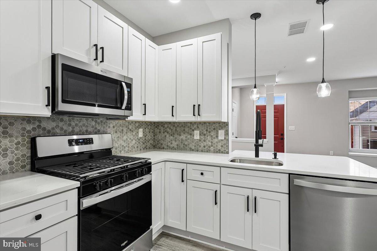 8737 Autumn Ridge Court Odenton, MD 21113 - Photo 3 of 46 a kitchen with a sink stove and microwave