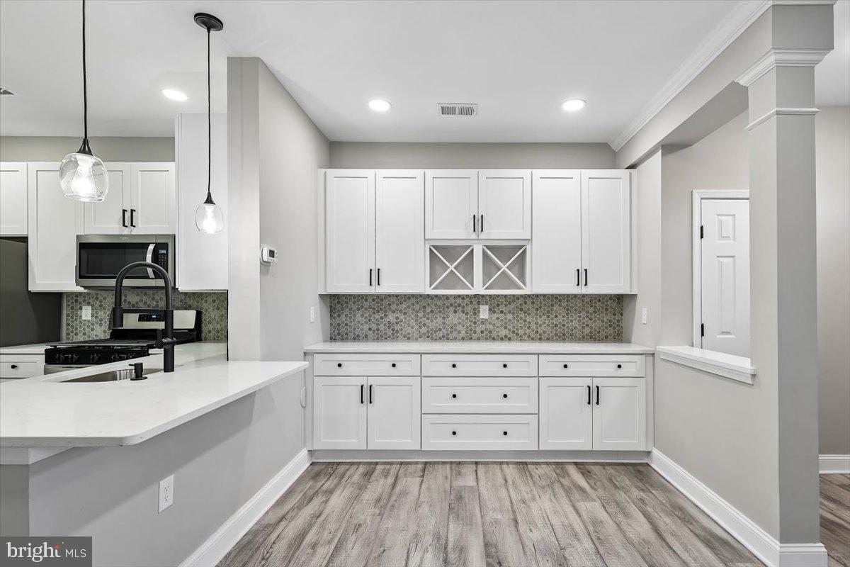 8737 Autumn Ridge Court Odenton, MD 21113 - Photo 6 of 46 a kitchen with stainless steel appliances kitchen island granite countertop a stove and a wooden cabinets