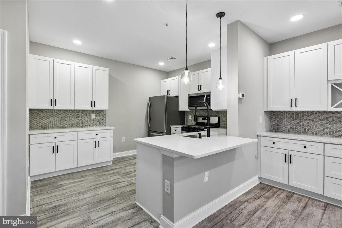 8737 Autumn Ridge Court Odenton, MD 21113 - Photo 7 of 46 a kitchen with white cabinets and white appliances