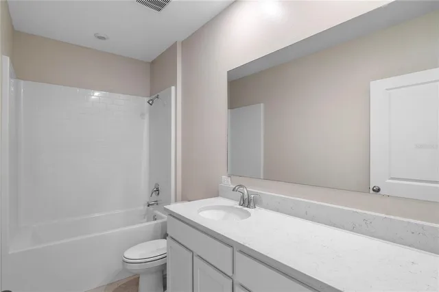 a bathroom with a sink toilet tub vanity and shower