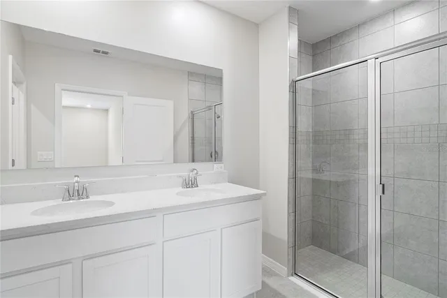 a bathroom with a shower sink and mirror
