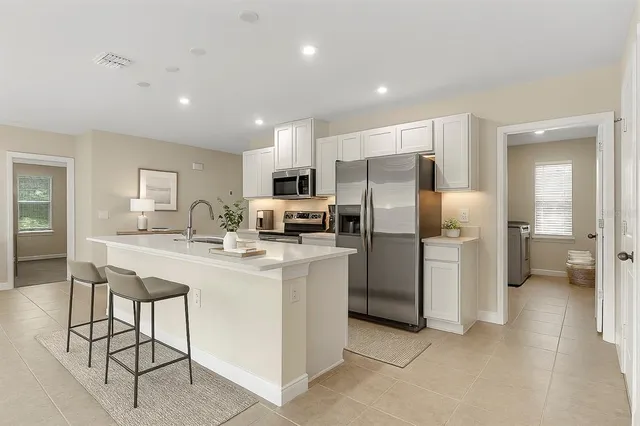 a kitchen with refrigerator and chairs