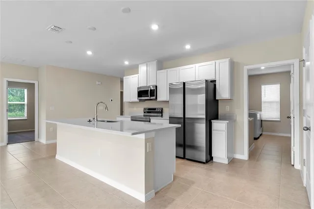 a kitchen with refrigerator and cabinets