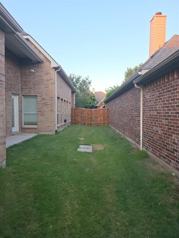 8047 New Kent Road Frisco, TX 75035 - Photo 9 of 27 Private outdoor space featuring a wood fence, brick exterior, and a concrete patio area