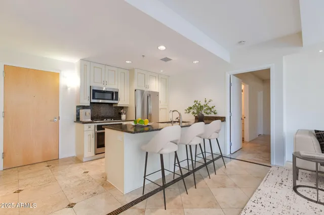 a kitchen with stainless steel appliances kitchen island granite countertop a refrigerator and microwave