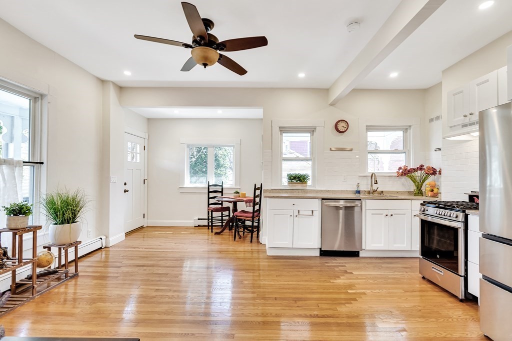 a kitchen with granite countertop a refrigerator stove top oven and sink