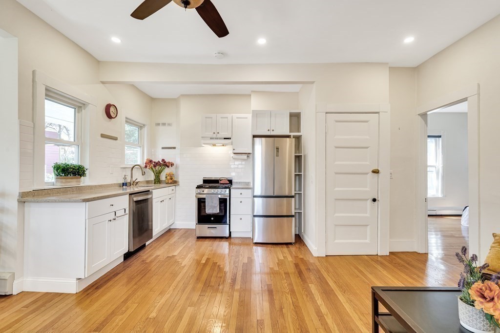 12 Rindge Avenue, Unit 2 Cambridge, MA 02140 - Photo 4 of 25 a kitchen with white cabinets and stainless steel appliances