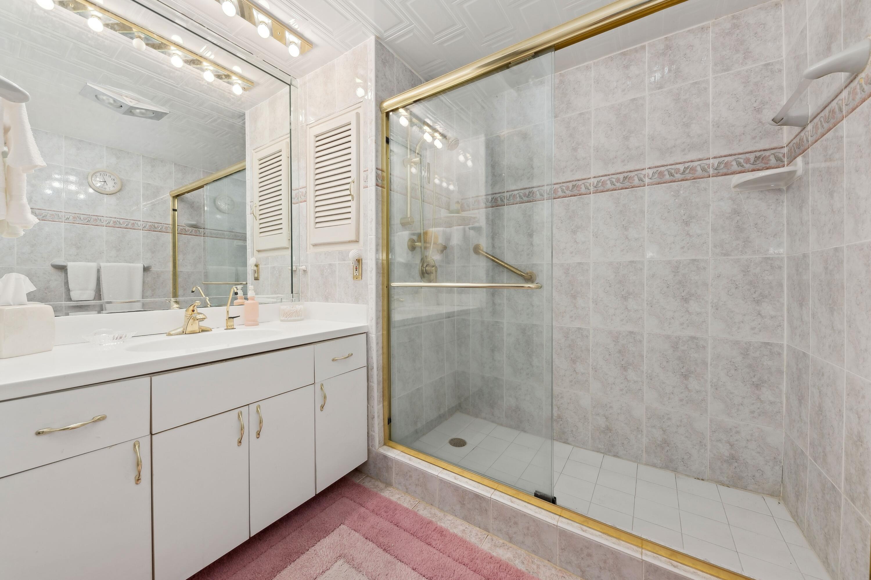 50 E Road, Unit 11F Delray Beach, FL 33483 - Photo 19 of 31 a bathroom with a shower and a sink a mirror