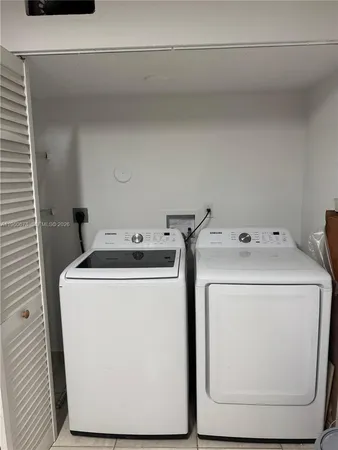 a view of a backyard with wooden fence and a large tree