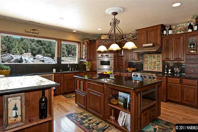 4840 Livery Road Reno, NV 89521 - Photo 4 of 12 a kitchen with stainless steel appliances granite countertop a stove a sink dishwasher and cabinets with wooden floor