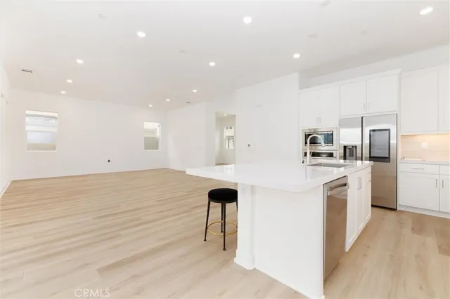 a kitchen with white cabinets and appliances