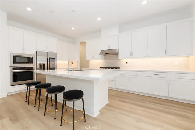 a kitchen with cabinets and chairs