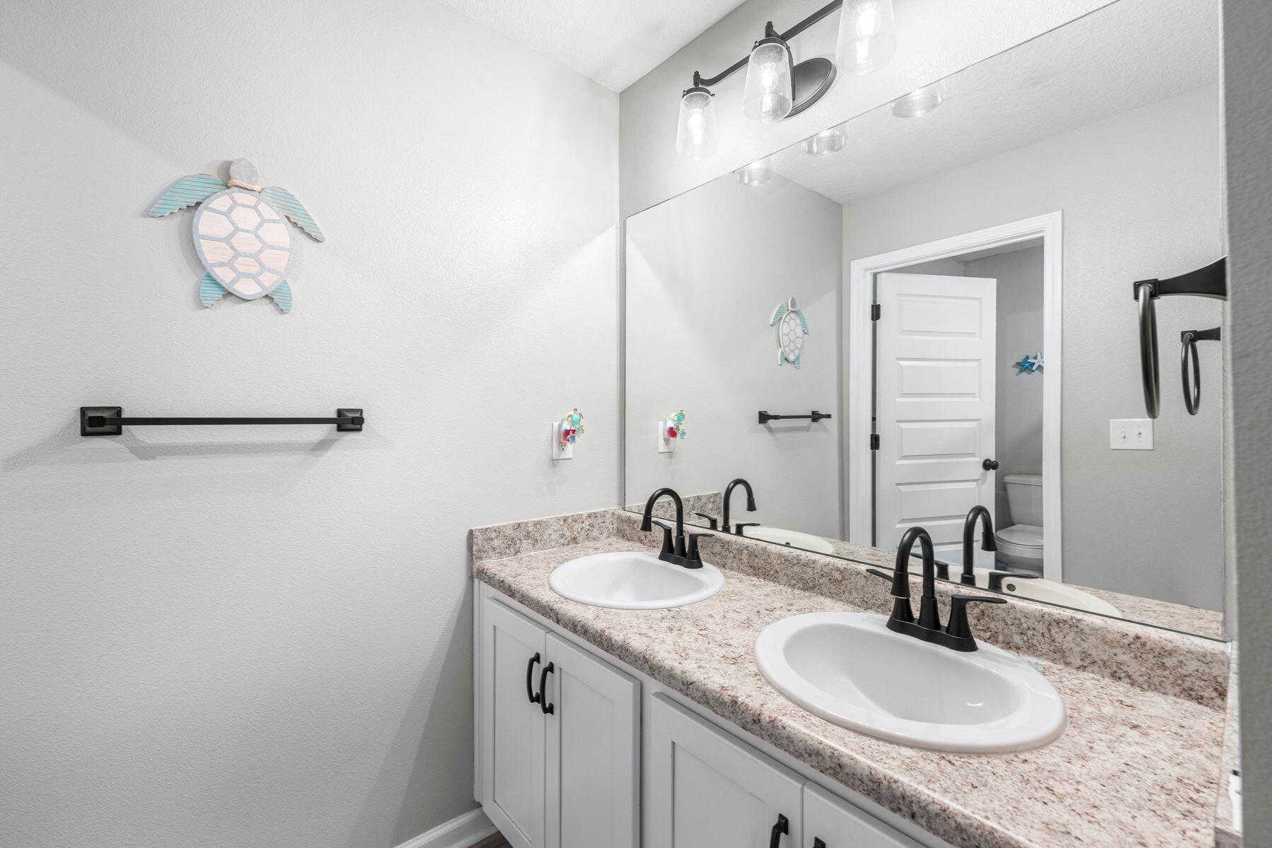 396 This Way Freeport, FL 32439 - Photo 20 of 30 a bathroom with a granite countertop sink a mirror and vanity