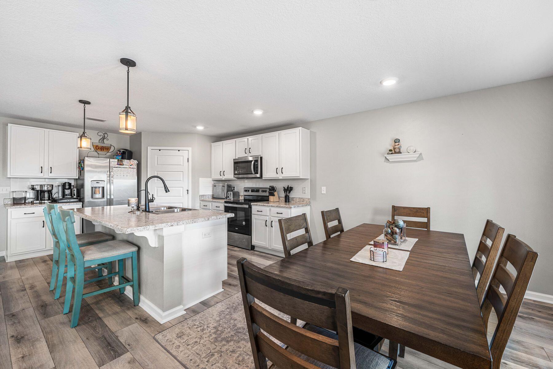 396 This Way Freeport, FL 32439 - Photo 8 of 30 a open dining room with stainless steel appliances kitchen island granite countertop a dining table chairs and a refrigerator