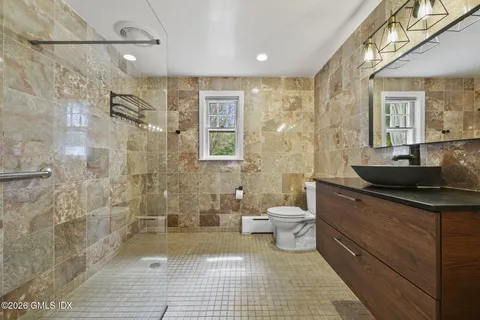a bathroom with a sink a toilet and shower