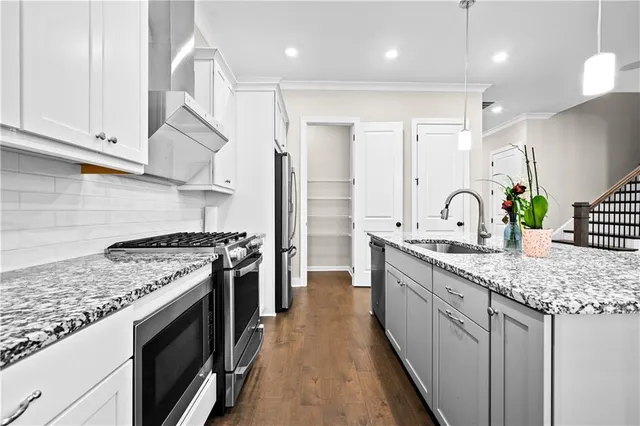 a kitchen with stainless steel appliances granite countertop a stove a sink and a refrigerator