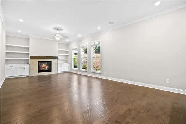 an empty room with fireplace and wooden floor