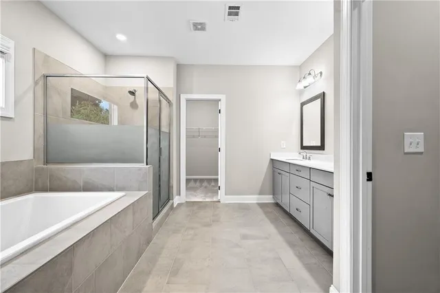 a bathroom with a tub sink shower and mirror