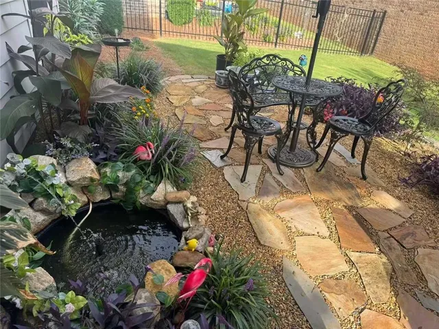 a backyard of a house with table and chairs