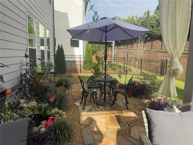 a view of a patio with table and chairs under an umbrella