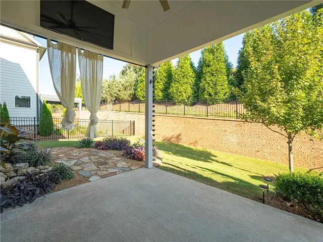 a view of an empty room with a floor to ceiling window and chair