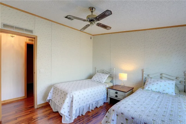 a bedroom with two beds and a ceiling fan