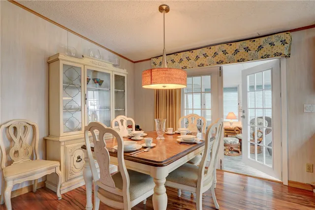 a dining room with furniture a chandelier and wooden floor