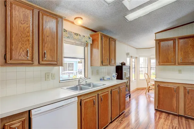 a kitchen with stainless steel appliances granite countertop a sink stove and wooden cabinets