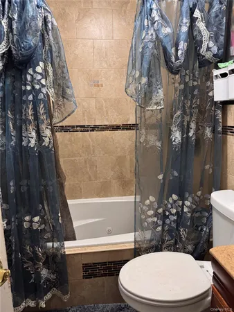a white toilet sitting next to a bath tub and a shower