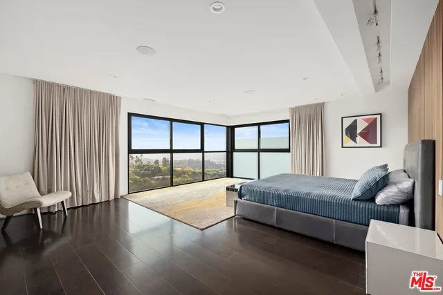 a living room with a bed furniture and a large window