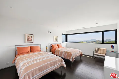 a bedroom with two beds and a large window