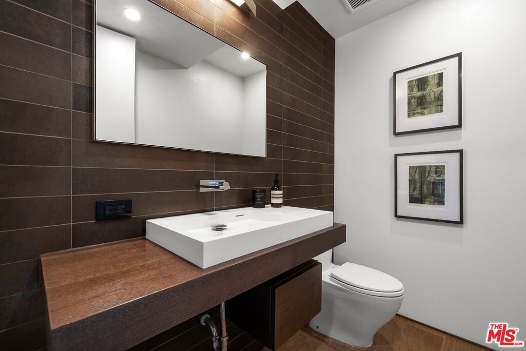 3337 Beverly Ranch Road Beverly Hills, CA 90210 - Photo 25 of 39 a bathroom with a sink a toilet and mirror