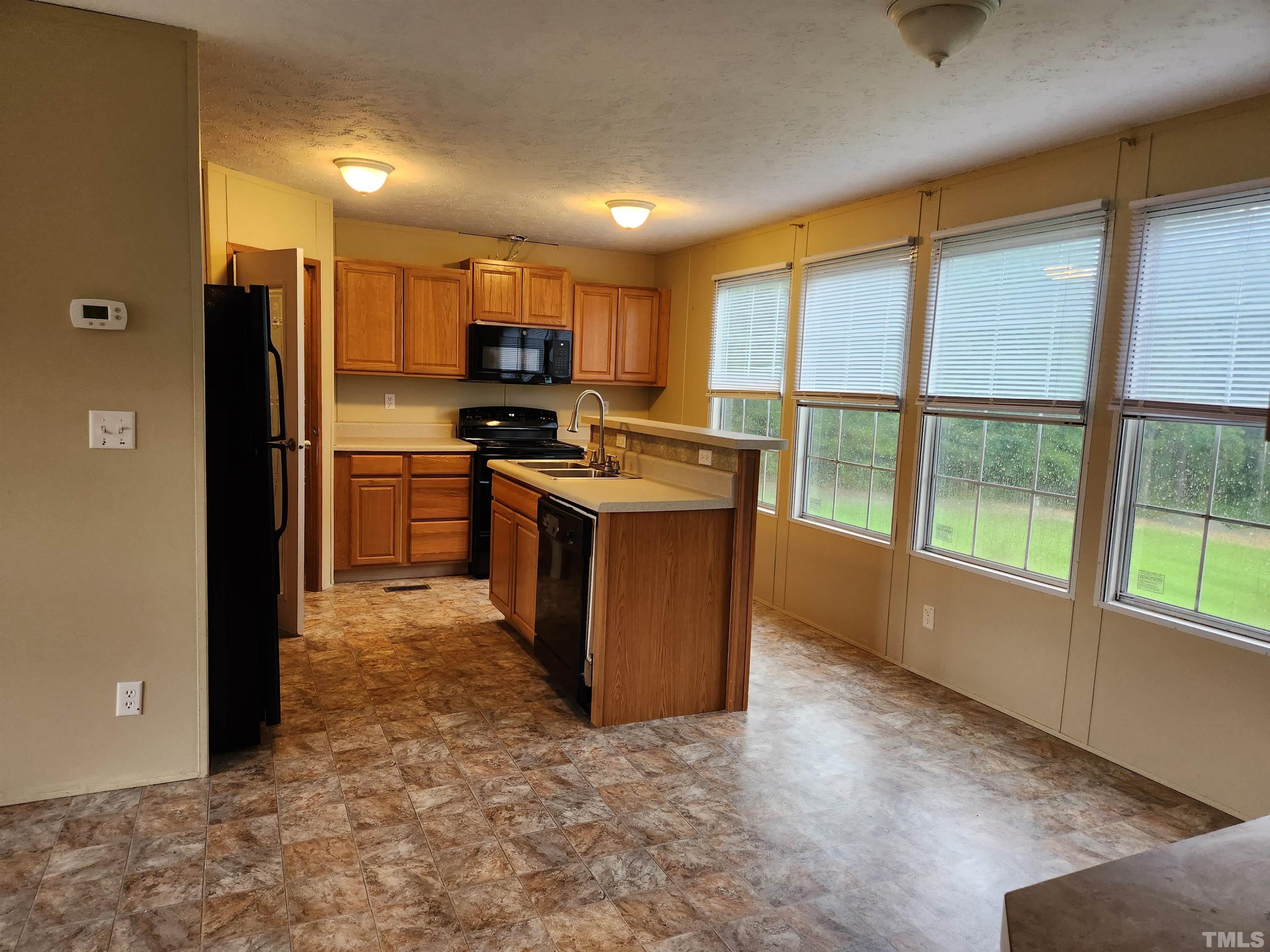 555 Massengill Pond Road Angier, NC 27501 - Photo 13 of 36 a kitchen with stainless steel appliances granite countertop a stove top oven a sink and a refrigerator