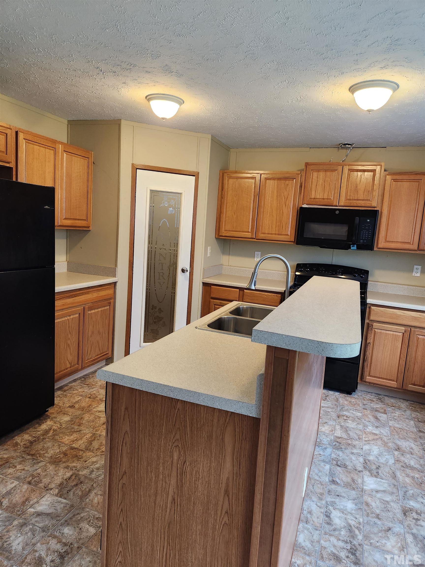 555 Massengill Pond Road Angier, NC 27501 - Photo 15 of 36 a kitchen with stainless steel appliances a stove a refrigerator a sink and a cabinets