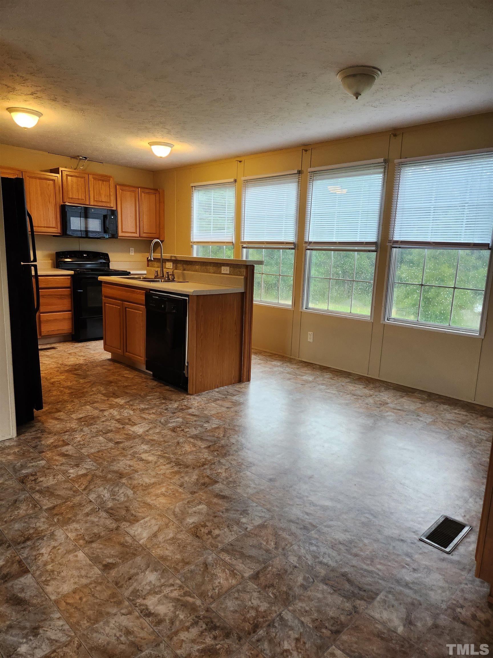 555 Massengill Pond Road Angier, NC 27501 - Photo 17 of 36 a large kitchen with kitchen island a large counter top space a sink a stove and a refrigerator