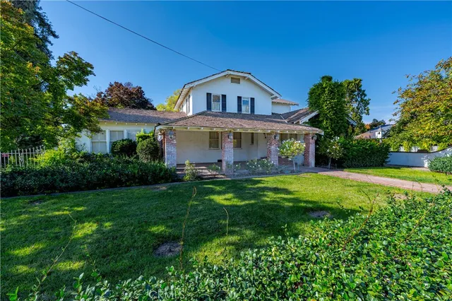 a view of house with garden and a yard