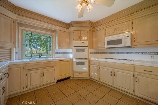 a kitchen with granite countertop white cabinets and window