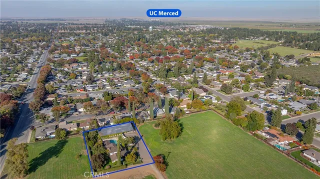 an aerial view of residential houses with outdoor space and trees