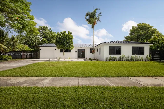 a front view of a house with a garden and yard