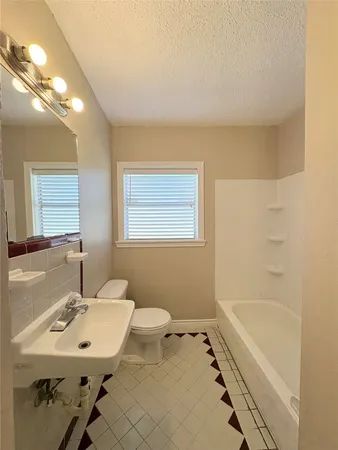 a bathroom with a sink mirror and a bathtub