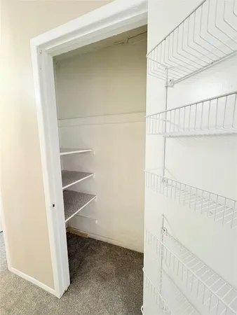 a view of walk in closet with empty racks