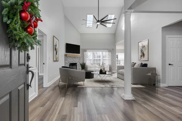 a living room with furniture a chandelier a window and a flat screen tv