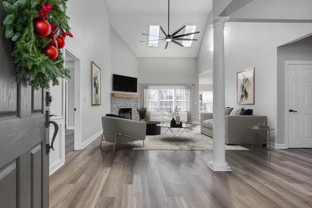 a living room with furniture a chandelier a window and a flat screen tv