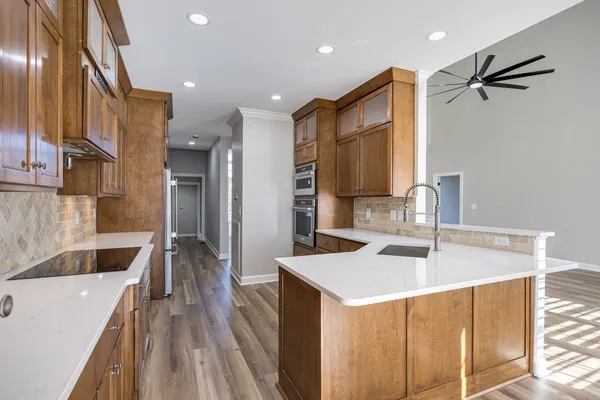 a kitchen with stainless steel appliances granite countertop a refrigerator and a stove top oven