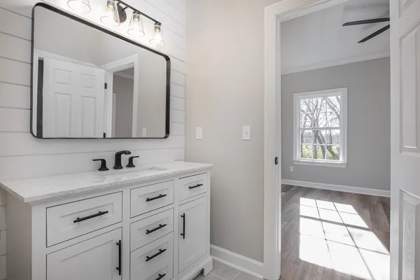 a view of a room with wooden floor a ceiling fan