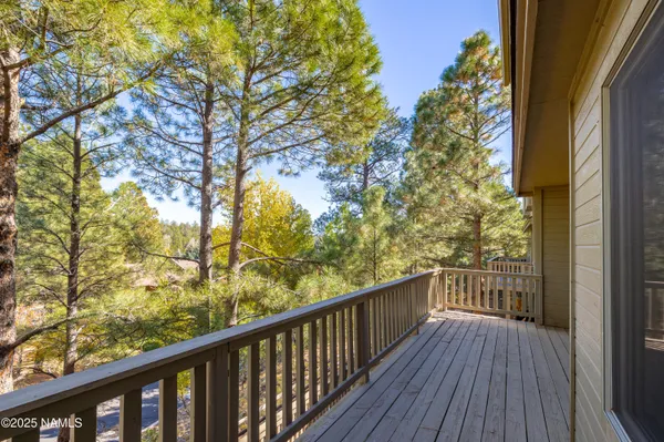 a view of a balcony with wooden floor and fence