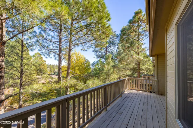 a view of a balcony with wooden floor and fence